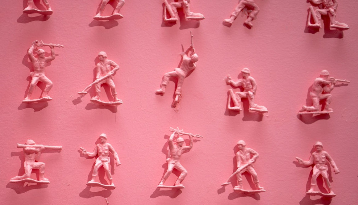 pink toy soldiers arranged on a pink background